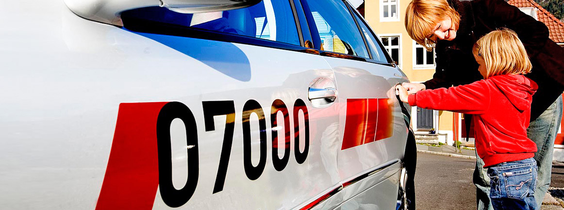 mor og barn som går inn i en taxi